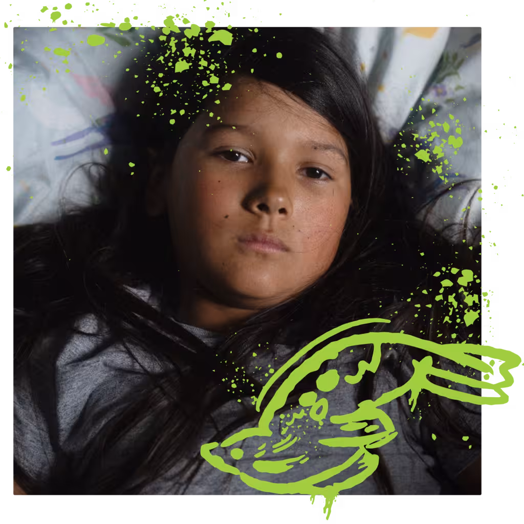 Close-up portrait of a young person with dark hair, lying down, with a green seal illustration.